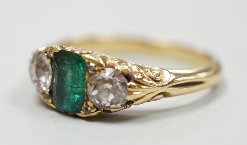 An early 20th century yellow metal, emerald and diamond set three stone ring, size L, gross weight 4.2 grams.